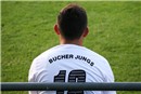 Ein Auswechselspieler der Gäste zeigt auf dem Rücken seines Shirts das Markenzeichen des Vereins: Bucher Jungs.