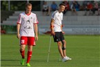 Philip Lang (li., TSV Buch) im Trikot mit dem Konterfei des verletzten Lukas Hofer, welcher mit Krücken direkt neben ihm steht.